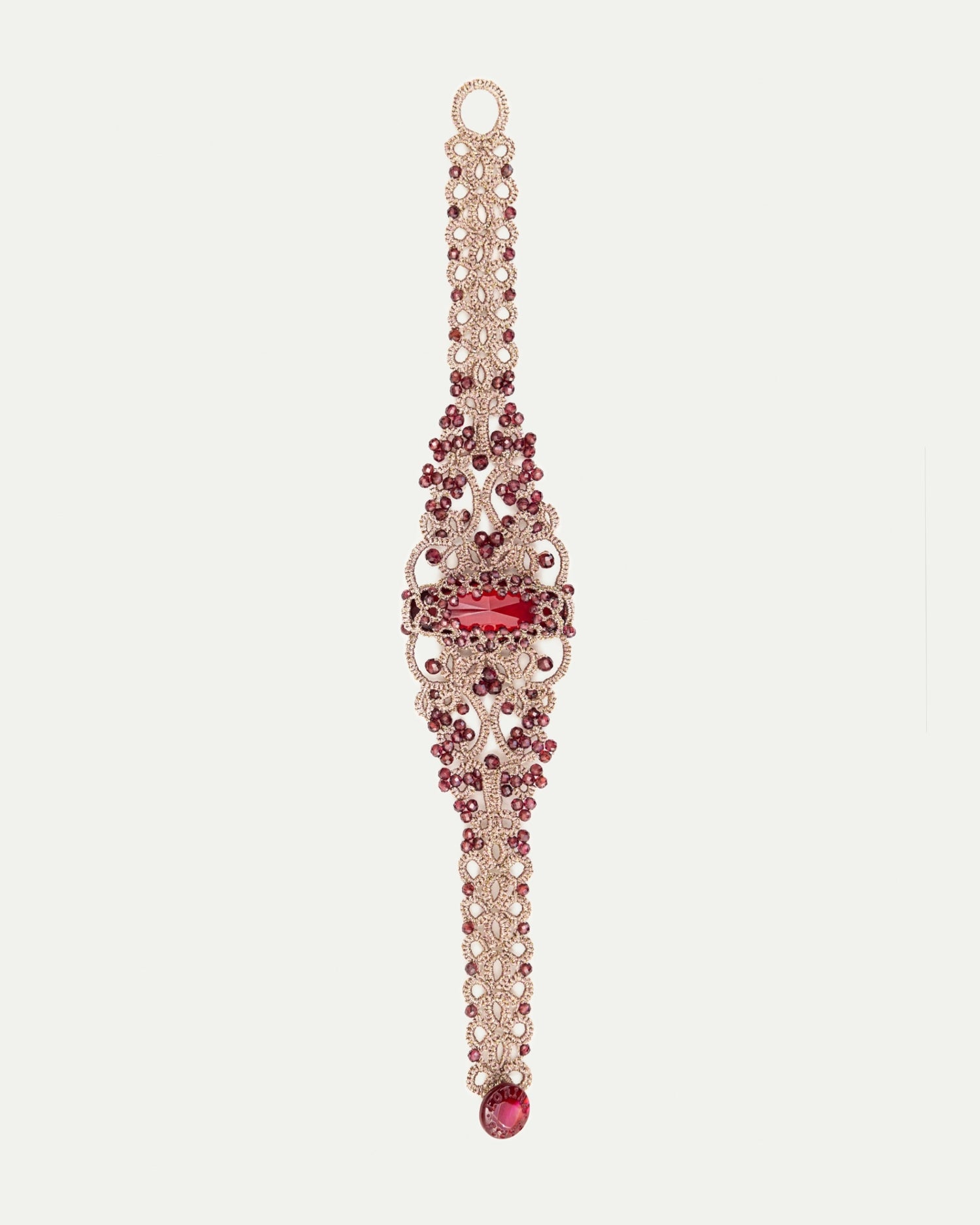Red ROZALINA bracelet with ornate lace design, intricate pearls, ruby gemstones, and metallic elements, side view.