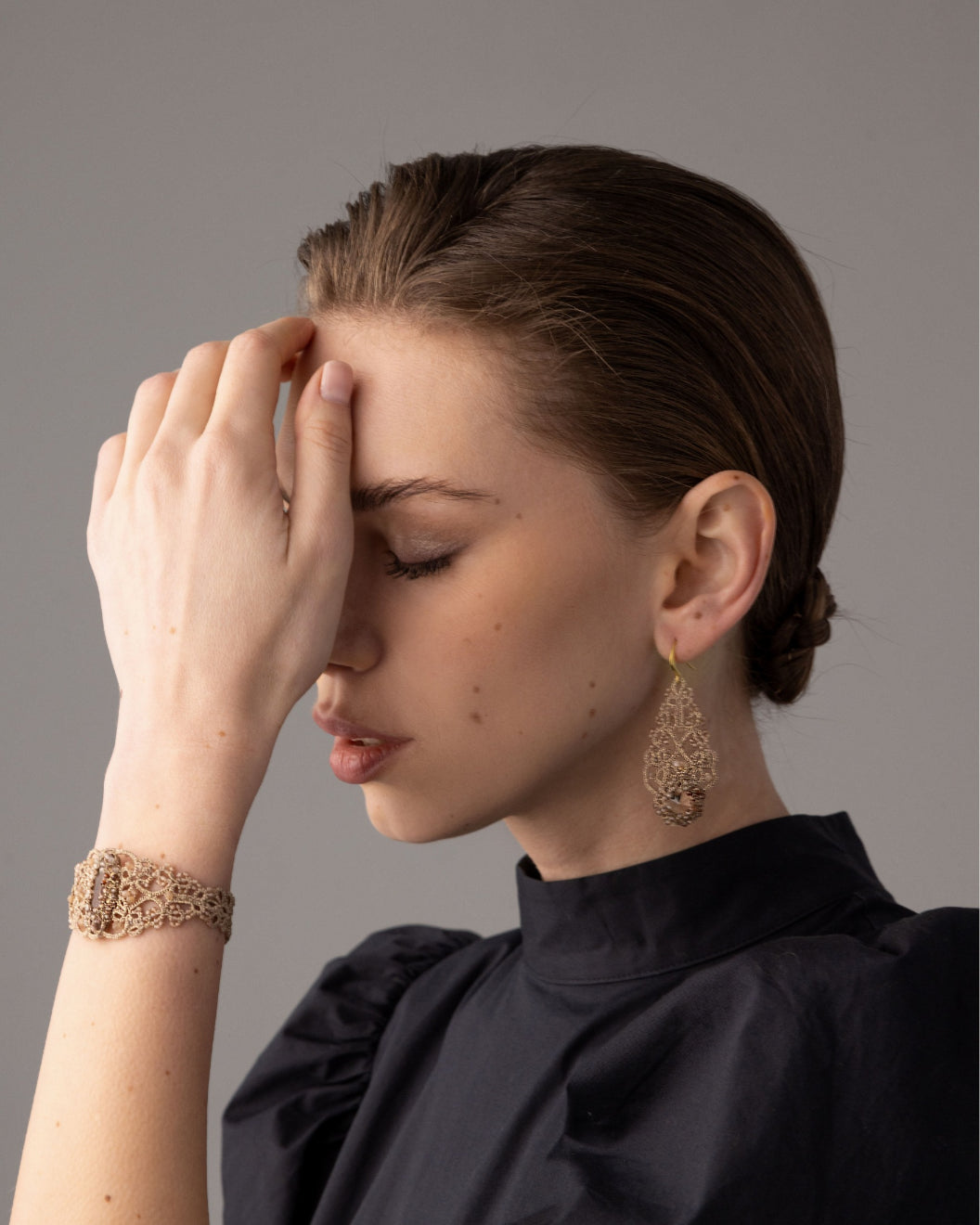 Gold ROZALINA BRACELET with intricate silk, pearl, crystal design; detailed texture showcased in side view.