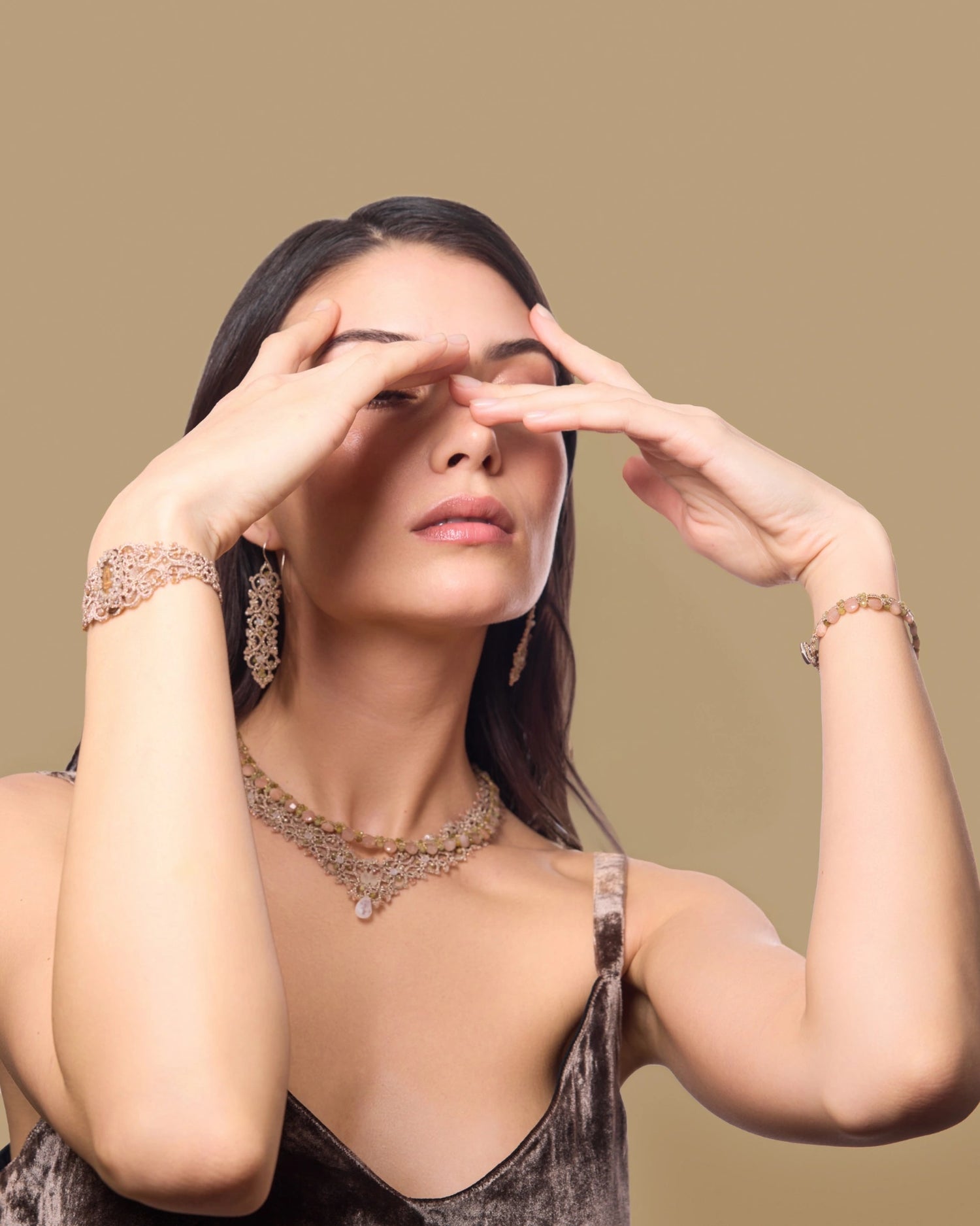 Gold ROZALINA bracelet with silk, pearl, and crystal detailing worn on wrist.