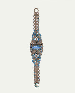 Intricate blue ROZALINA BRACELET with ornate metalwork, adorned with blue beads and central blue gemstone.