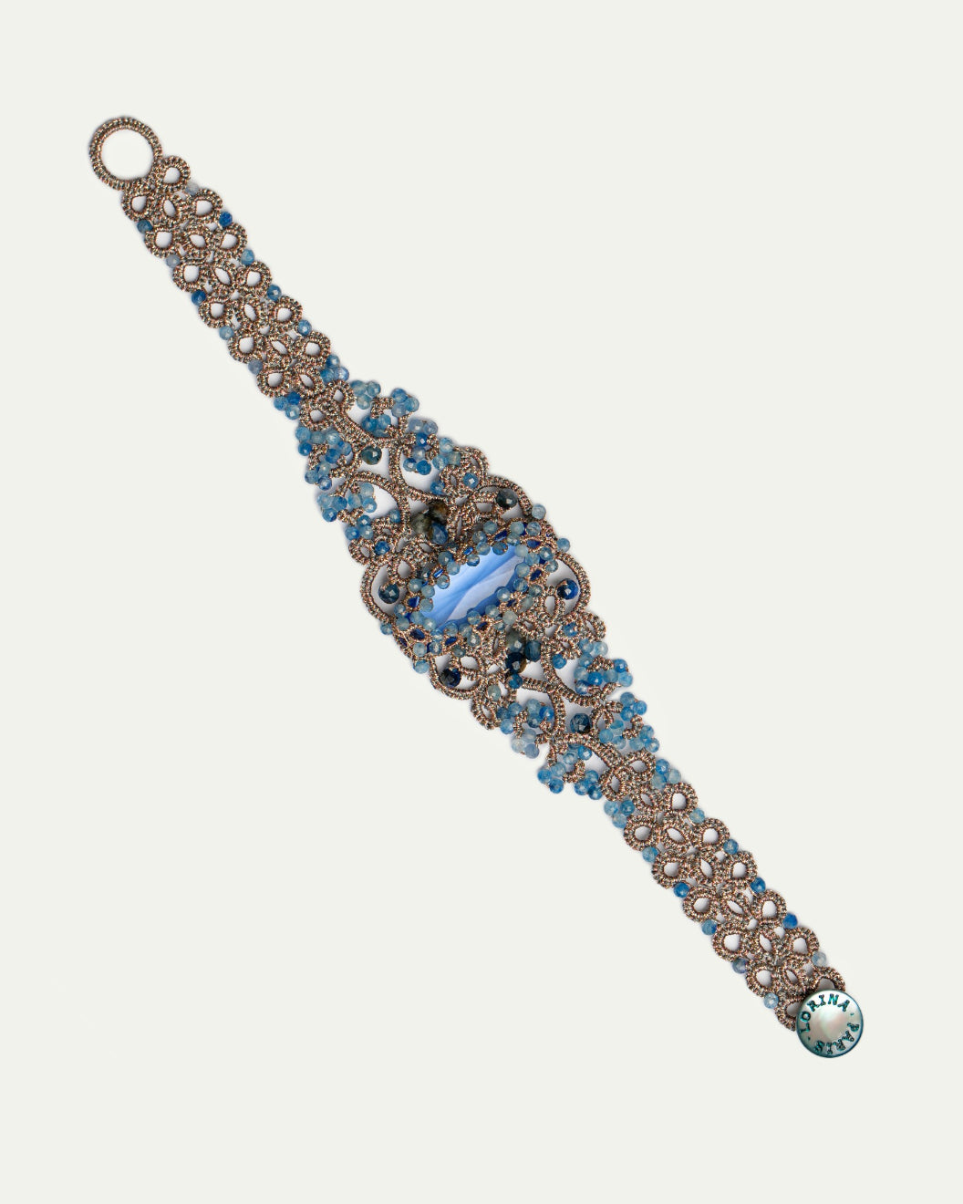 Blue silk bracelet with intricate design, featuring pearls, crystals, kyanite, and aquamarine details.