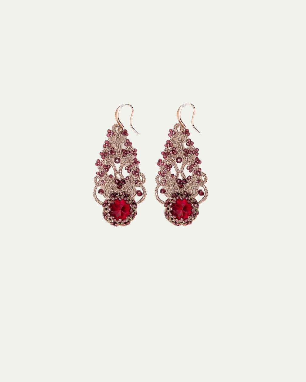Ornate red gemstone earrings with intricate gold filigree detailing and hook closure, elegant side view angle.