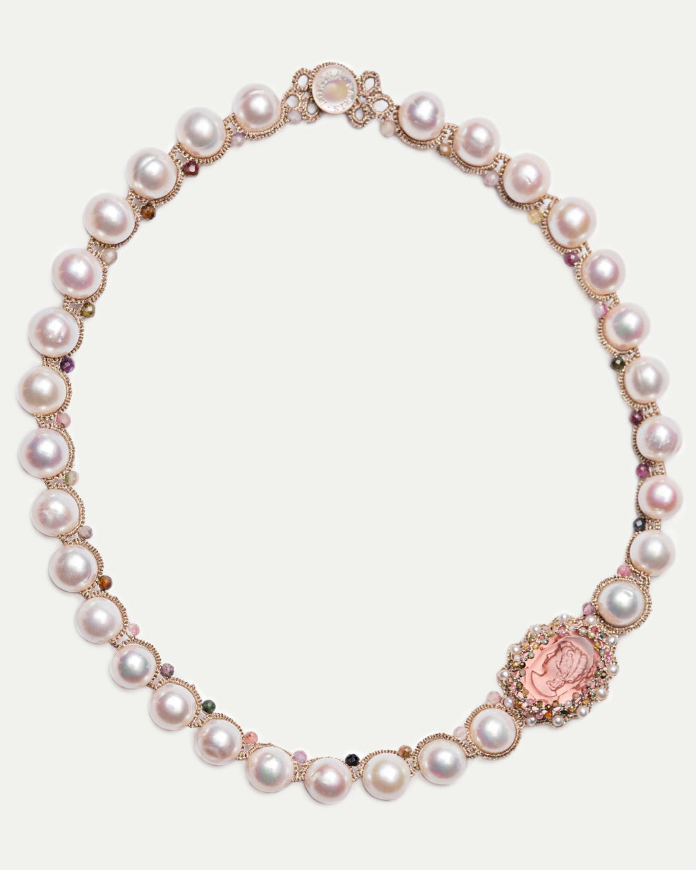 Rose gold Selene necklace with pearls, gemstone accents, and ornate medallion detailing, side view.