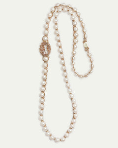 Gold pendant with pearls and crystals detail, showing intricate texture and elegant design elements.