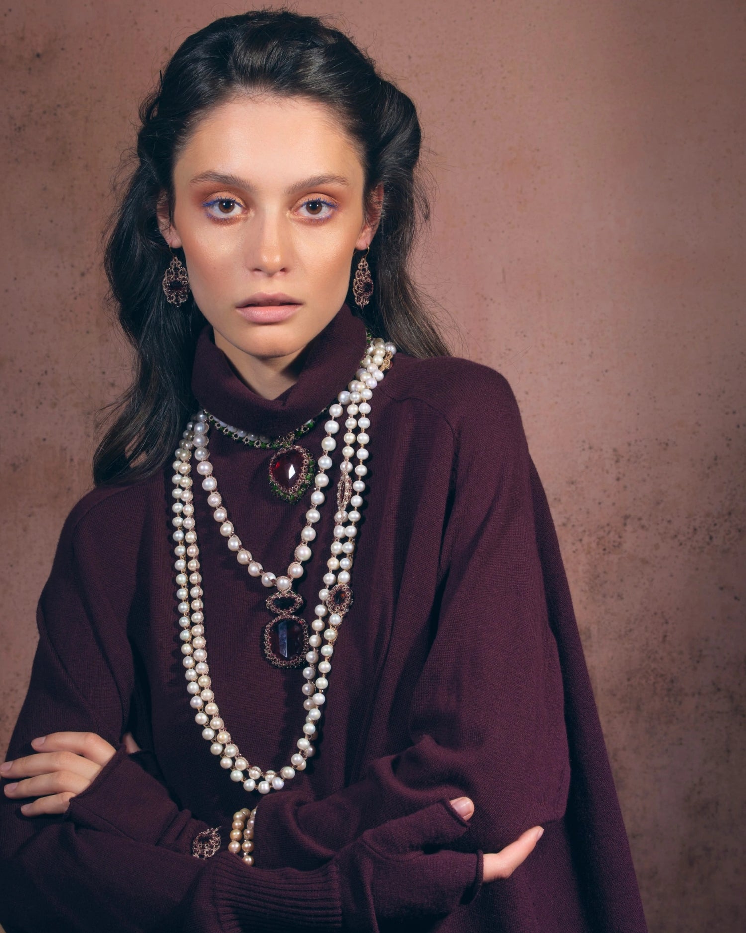 Red gemstone pendant with ornate detailing, worn with layered pearl necklaces, side view, luxurious jewelry design.