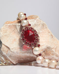 Red garnet and freshwater pearls on silk, detailed SHAYLA PENDANT with intricate beadwork on stone backdrop.