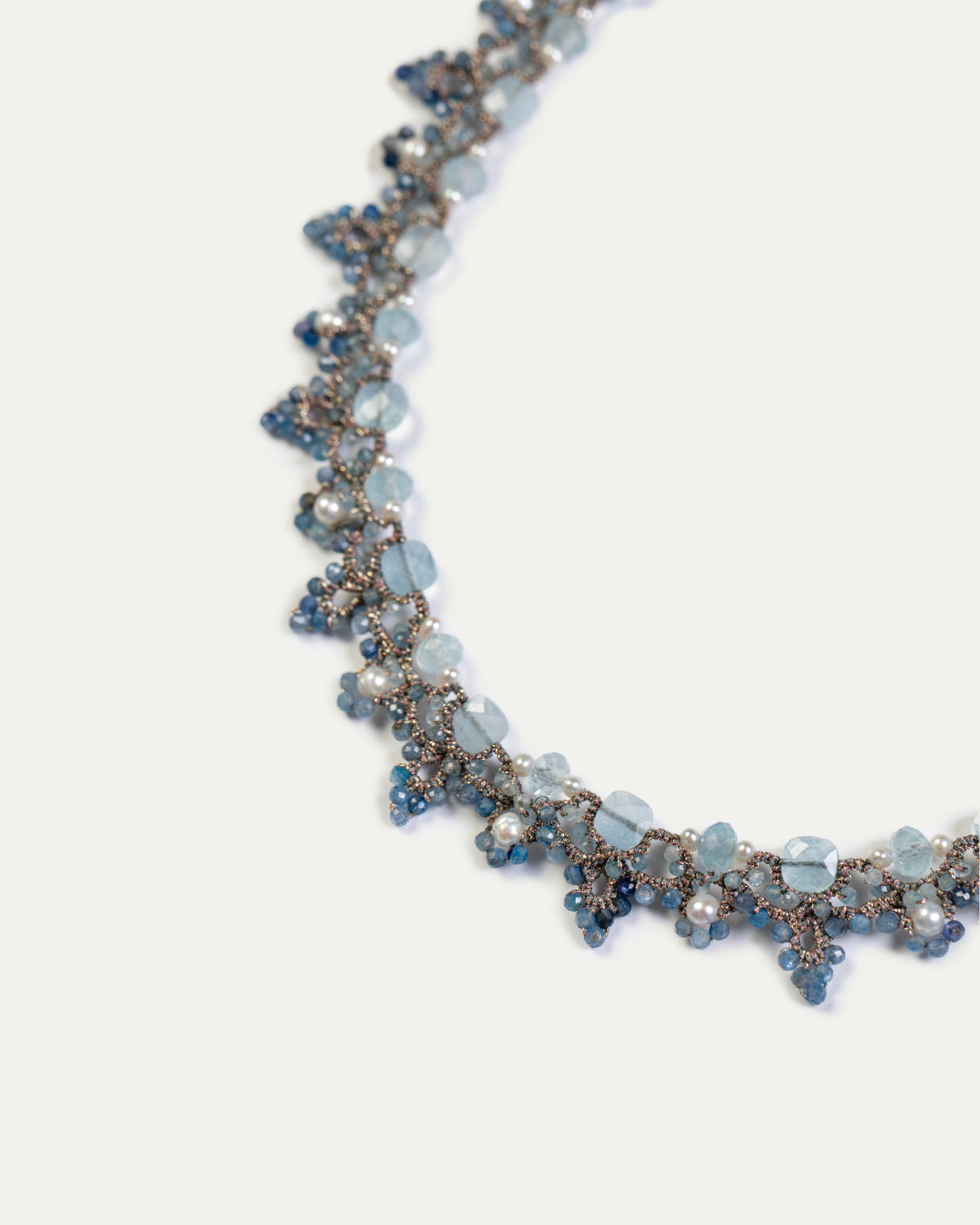 Blue Valeria Necklace with faceted gemstones, intricate silver chain design, delicate pearl accents, side view.