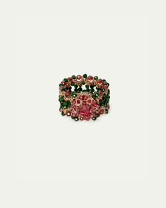 Gold ring with pink and green gemstones in floral design, intricate detailing, side view angle.