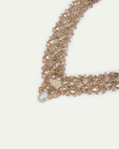 Gold Vintaj necklace detail with intricate silk design, pearls, garnet stones, and textured pattern.