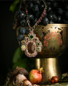 Pandantiv SYDNEY, mătase roze, perle, cristale, pietre kyanite și safir, detaliu într-un fundal decorativ.